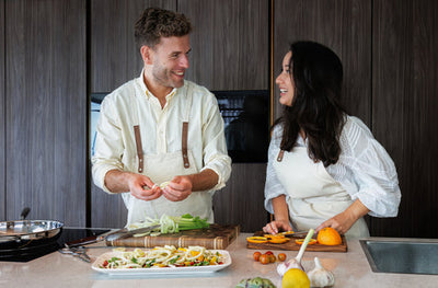 Stel kookt samen voor Valentijnsdag met SOPHIOR snijplank en koekenpan in moderne keuken