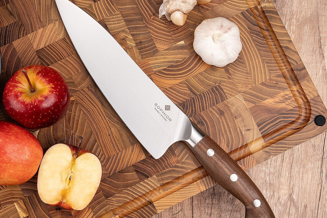 SOPHIOR koksmes 21 cm met walnoothouten handvat op een kopshouten snijplank met appel en knoflook