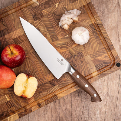 SOPHIOR koksmes 21 cm met walnoten heft op houten kopshout snijplank met appel en knoflook