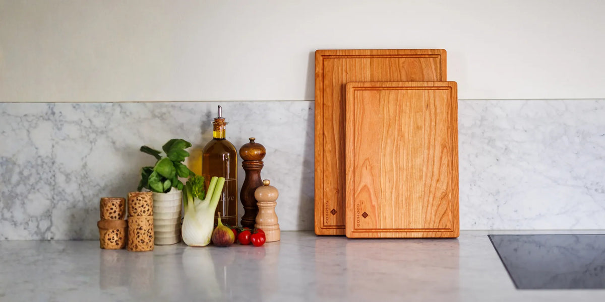 Houten snijplankenset van kersenhout op een werkblad in een lichte keuken