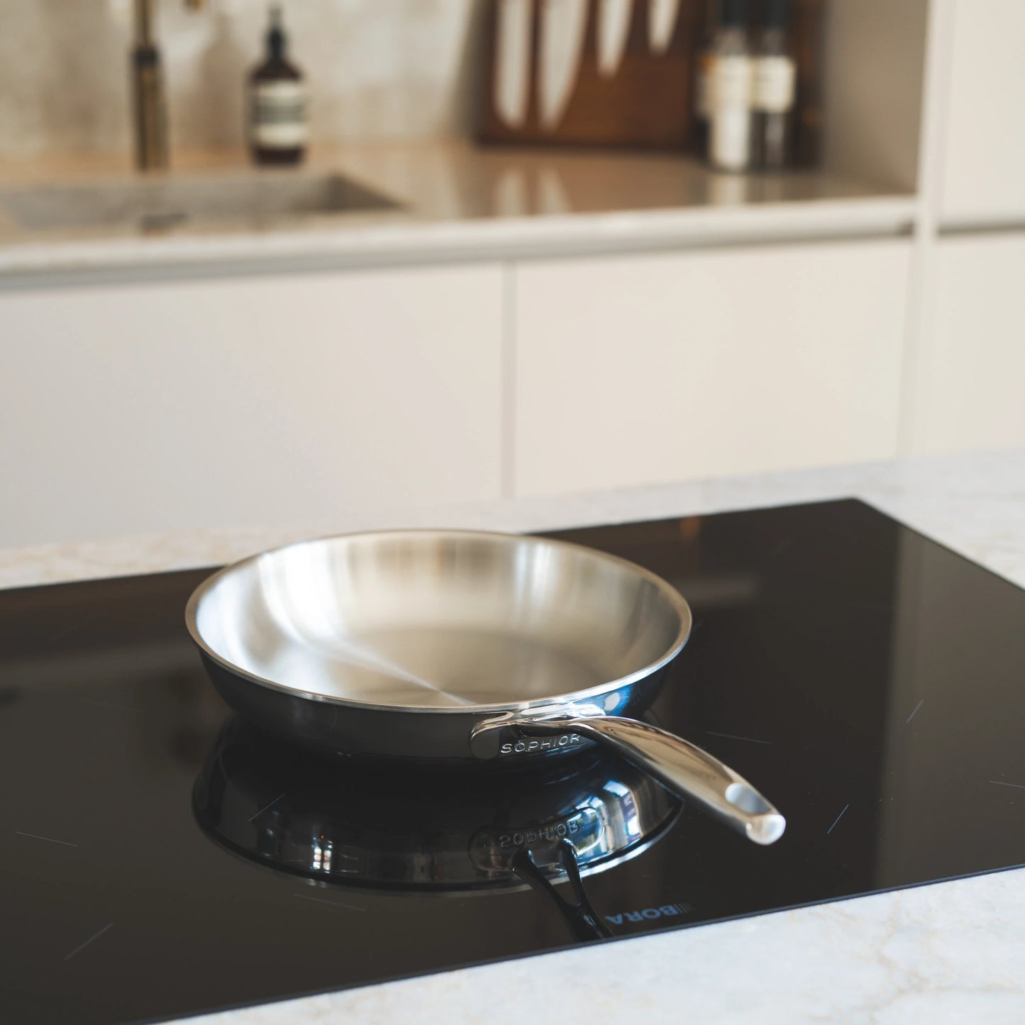 RVS koekenpan Ø24 cm staand op inductiekookplaat in lichte keukensetting