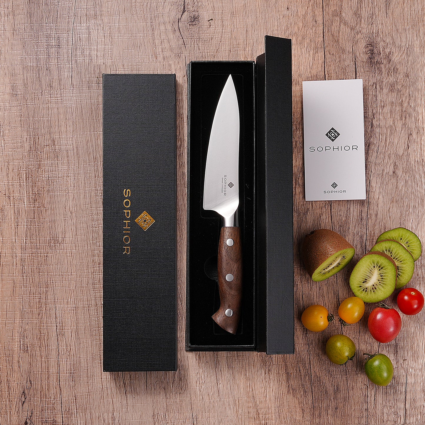 Koksmes 14 cm in geopende zwarte geschenkverpakking met kiwi en tomaten ernaast