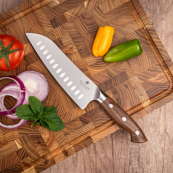 Santoku 19 cm op kopshout snijplank met tomaat ui en paprika