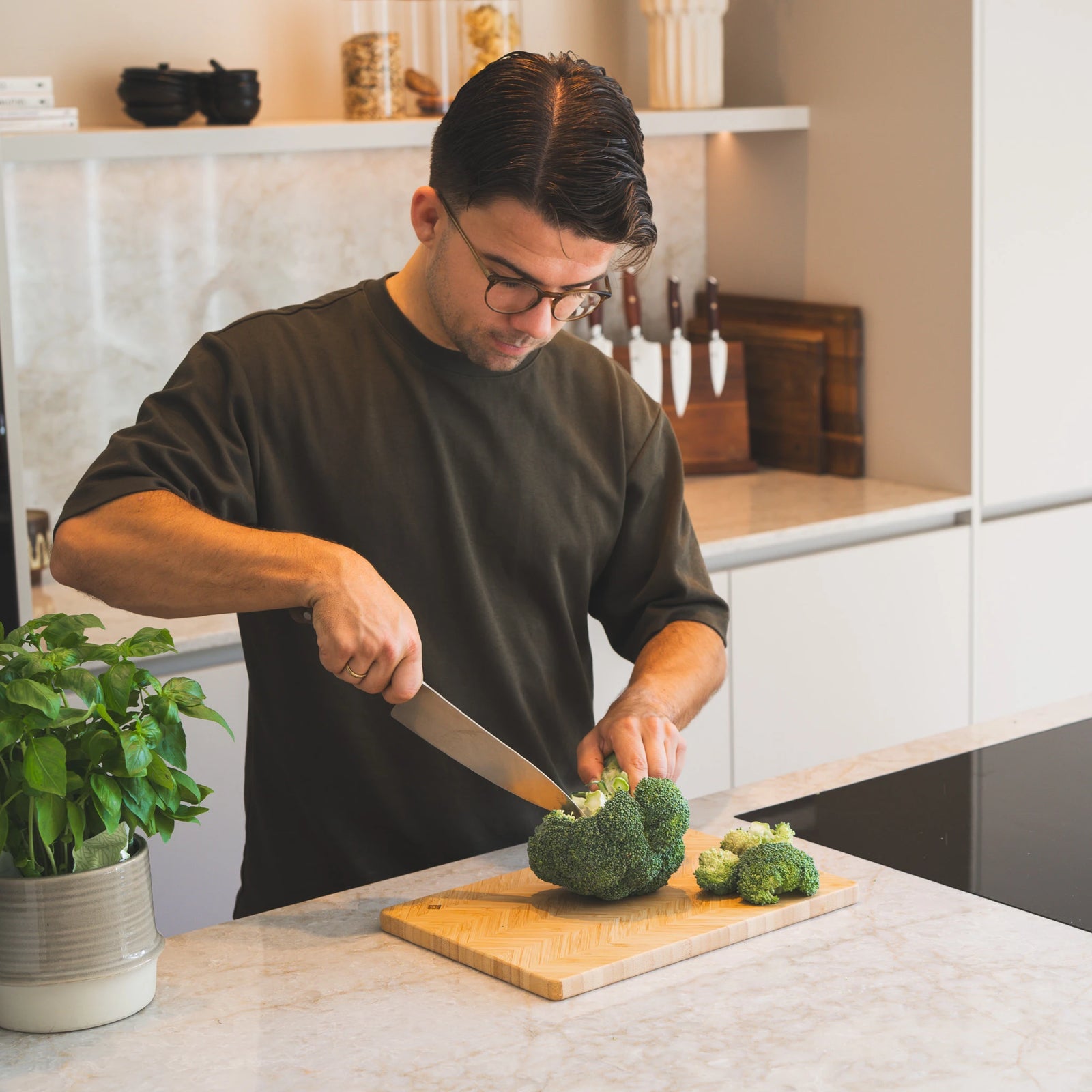 Bamboe Snijplankenset in gebruik bij het snijden van broccoli in lichte keuken