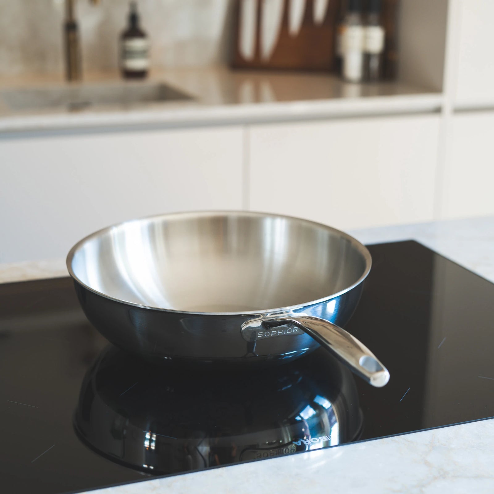 RVS Wokpan Ø30cm op inductiekookplaat met SOPHIOR-logo zichtbaar op zijkant