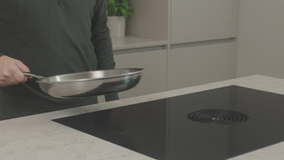 Productvideo: RVS koekenpan 28 cm wordt boven inductiekookplaat gehouden in moderne keuken