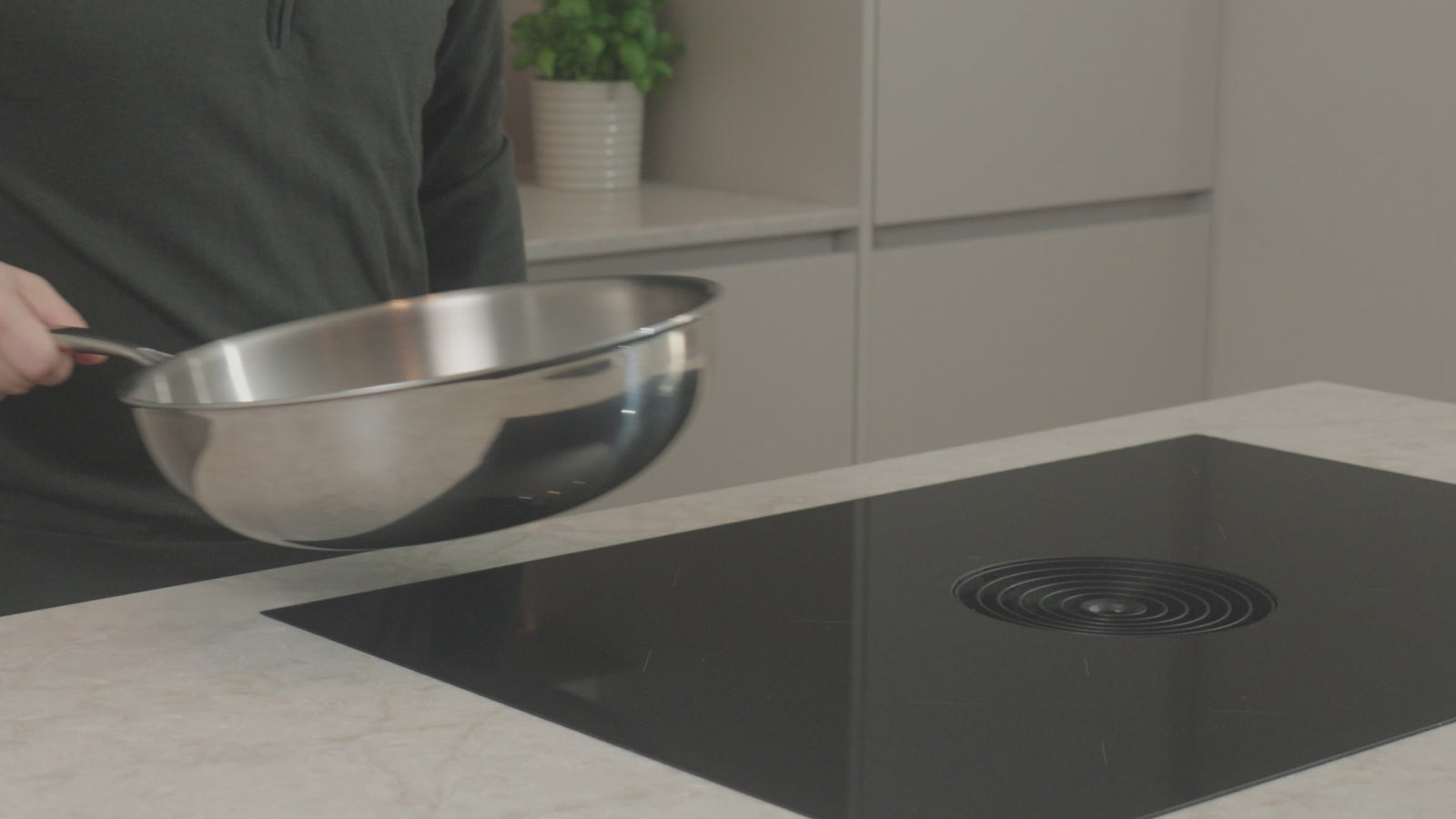 Productvideo: RVS wokpan 30 cm wordt boven inductiekookplaat gehouden in moderne keuken