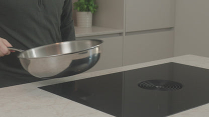 Productvideo: RVS wokpan 30 cm wordt boven inductiekookplaat gehouden in moderne keuken