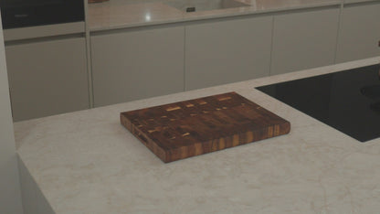 Productvideo: acacia kopshout snijplank 40x30x3,5 cm op een licht keukenblad naast inductiekookplaat