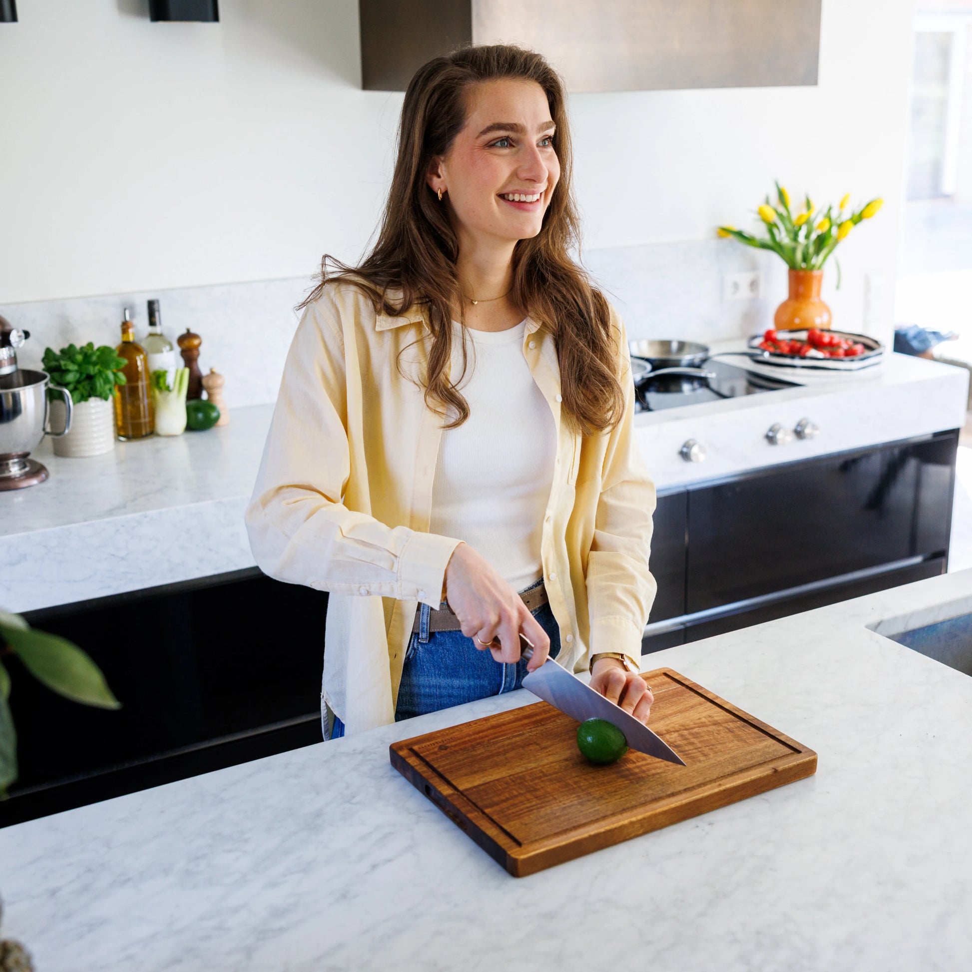 Houten Snijplank Acacia – 42×30×2,5 cm in gebruik door lachende vrouw in moderne keuken