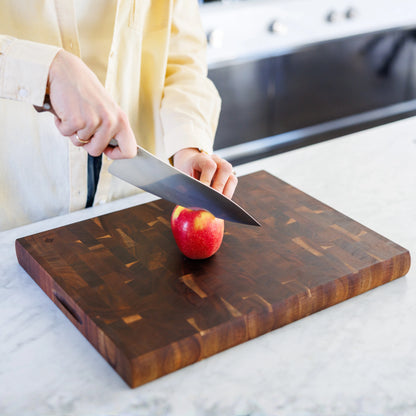 Houten Snijplank Acacia Kopshout – 45×35×4 cm in gebruik tijdens snijden van een appel op marmeren werkblad
