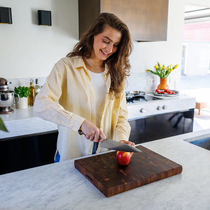 Houten Snijplank Acacia Kopshout – 45×35×4 cm in gebruik door lachende vrouw in moderne keuken