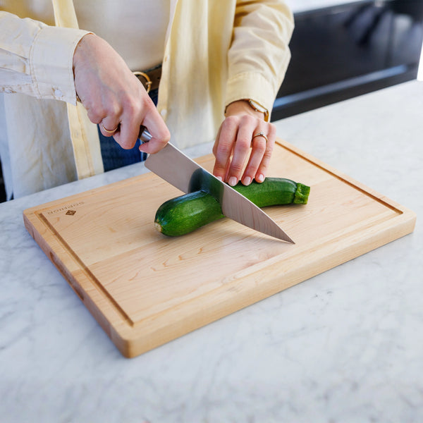 Houten Snijplank Esdoorn 42x30x2,5 cm tijdens het snijden van een courgette