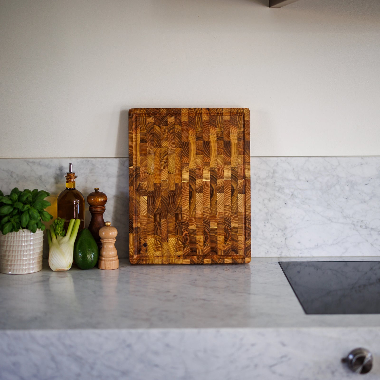 Houten Snijplank Teak Kopshout – 45×35×4 cm rechtop op marmeren aanrecht in keukensetting